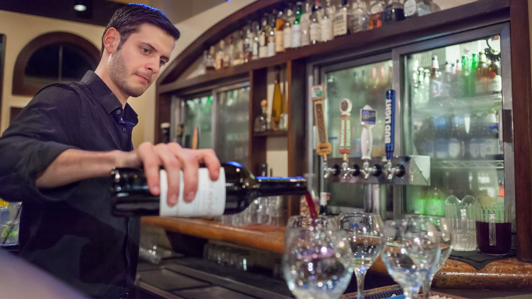 Bartender pouring wine at the bar